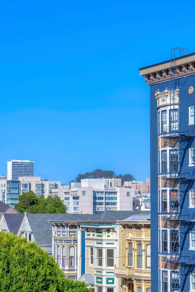 Rows of traditional and modern apartment buildings at San Francisco, California. There are traditional apartment buildings at the front with victorian style exterior and modern builldings at the back.