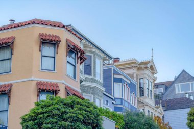Row of houses in a low angle view at San Francisco, California. Italianate, traditional, and victorian houses in a row against the clear sky background.