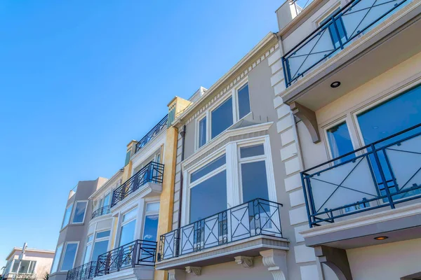 Modern townhouses with balconies and picture windows in a low angle view at San Francisco, CA. Three-storey townhomes with european exterior and reflective windows.