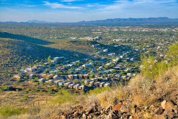View of suburban homes from a mountain at Tucson, Arizona. High angle view of a desert landscape in between the mountains against the sky.