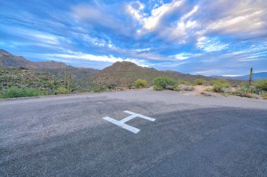 Helipad at Sabino Canyon State Park in Tucson, Arizona. Emergency helicopter landing with a view of mountain range with saguaro cactuses on the slope against the sky.