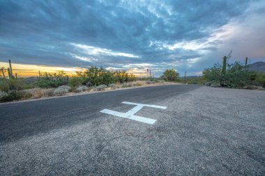 Helipad near the shrubland at Sabino Canyon State Park in Tucson, Arizona. Helicopter landing area against the sunset skyline and mountains.