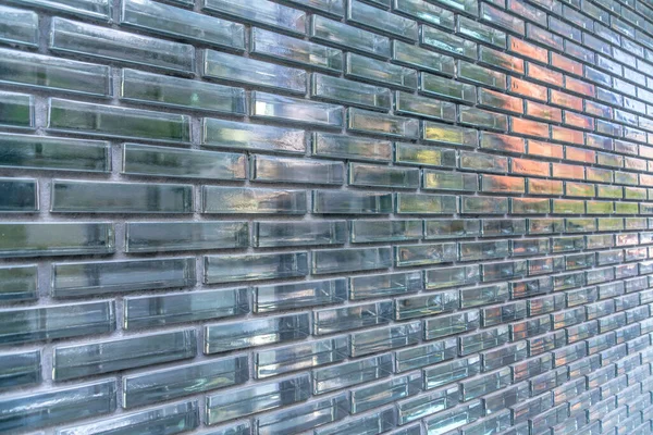 Reflective optical glass brick walls at Austin, Texas. Exterior of a building with glass brick walls with a reflections in a running bond pattern.