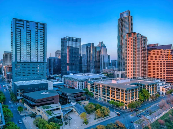 Commercial and residential buildings at Austin, Texas. There are highways in between the skycrapers with reflective glass walls against the sky.