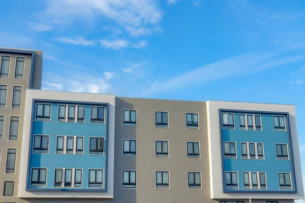 Modern apartment building with casement windows in San Francisco, California. Facade of a residential building with gray and blue colors against the clear sky background.