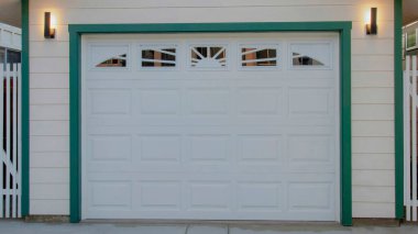 Panorama White puffy clouds Detached garage in between two white buildings at Oceanside, California. Garage exterior with white sectional door