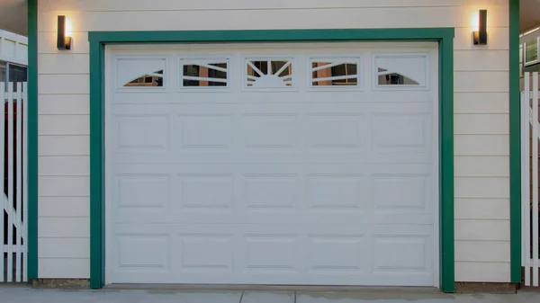 Panorama White puffy clouds Detached garage in between two white buildings at Oceanside, California. Garage exterior with white sectional door