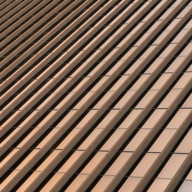 Square Building exterior with bronze reflective glass screen at Salt Lake City in Utah. Low angle view of a building with brown concrete wall claddings.
