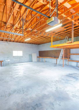 Vertical Large garage interior with automatic door operator machine. Interior of an unfinished garage with wooden frameworks, window and hollow blocks wall.