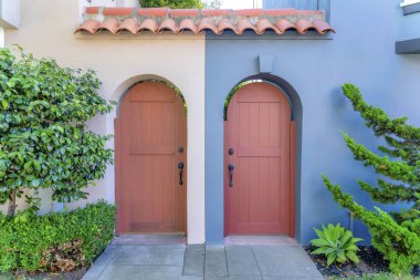 San Francisco, California 'da beton girişi olan iki mahalle kemerli kapı. Ön kapıda, soldaki bej duvarın yanında ve sağdaki gri duvarda bitkiler var..