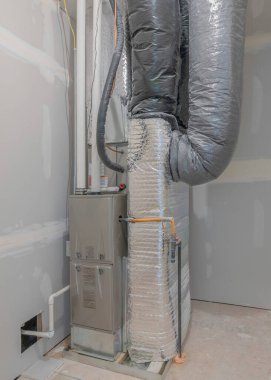 Dolap odasındaki duvarda beyaz işaretler olan dikey havalandırma sistemi. Bir evin merkezi ısıtıcı, havalandırma ve havalandırma sistemiyle depolama..