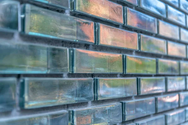 Close-up of a glass brick walls with reflective texture at Austin, Texas. Running bond pattern of a glass bricks with glossy exterior.