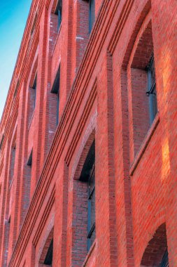 Kırmızı tuğla duvarı ve kemerli pencereleri olan çağdaş bir binanın dış görünüşü. Modern konutun kapanışı San Francisco California caddesinden görülüyor..
