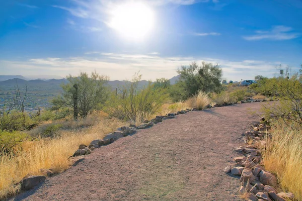 Hiking trail in the mountain overlooking scenic nature views on a sunny day. Pathway lined with rugged stones in the mountains of Tucson Arizona for tourist hikers.