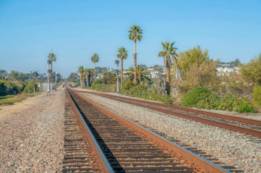 Uçurumdaki evlere karşı paslı rayları ve açık mavi gökyüzü olan demiryolu. Güneşli bir günde, Del Mar Güney Kaliforniya 'da deniz kenarındaki bir mahallede demiryolu..