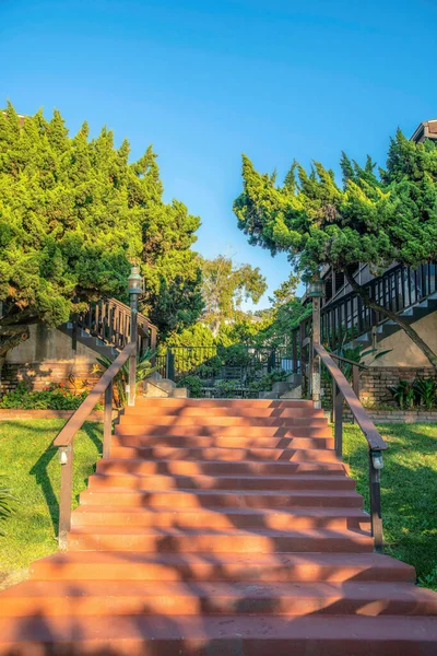 Flight of outdoor stairs along grasses trees and homes at Del Mar California. Outdoor scenic landscape at a beach side neighborhood community viewed on a asunny day.