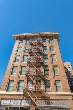 Mavi gökyüzüne karşı yangın çıkışı için merdiven boşluğu olan bir apartmanın dışında. San Antonio Teksas 'ın modern mimari manzarası. Konut binasının güvenlik merdivenleri var..