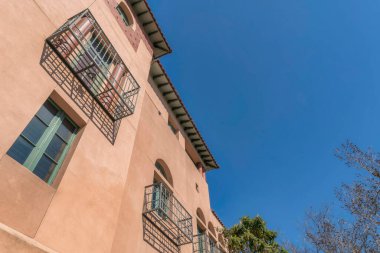 Kemerli pencereli ve balkonlu bir dairenin dış yüzüne bakıyorum. Austin Texas 'ta bir apartman binasının cephesi güneşli bir günde mavi gökyüzü arka planıyla görüldü.