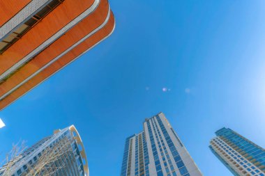 Güneşli bir günde apartman daireleri ve dairelerle mavi gökyüzüne bakıyorum. Austin Texas gökdelenleri ve modern yerleşim alanlarının dış görünüşüyle gökdelenler.