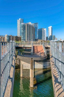 Colorado Nehri 'ne, bisiklet yollarına ve yürüyüş yollarına bakan lüks daireler. Austin Teksas manzaralı güneşli bir günde mavi gökyüzüne karşı konutlu binalar.