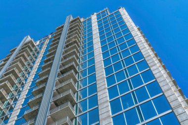 Austin Texas şehir merkezinde mavi gökyüzü geçmişi olan apartman birimleri. Güneşli bir günde şehir silueti modern konut mimarisine sahip konut binalarıyla birlikte..
