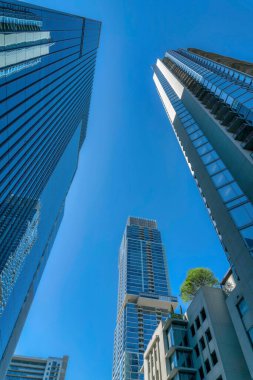 Austin Texas ufuk çizgisine bakıyorum. Parlak mavi gökyüzüne karşı daireleri olan. Modern mimari tasarımlı, balkonları ve cam cepheleri olan konut binalarının dışında..