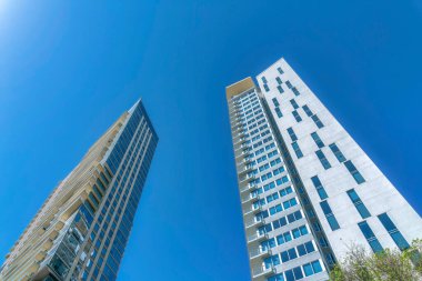 Güneşli bir günde parlak mavi gökyüzüne karşı balkonları olan bir bina. Austin Teksas 'ta modern mimari ile apartman ve dairelerin ön cephesine bakıyorum..
