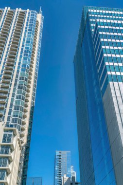 Austin Texas şehir merkezindeki gökdelenler parlak mavi gökyüzü arka planına sahipler. Güneşli bir günde camları yansıtan konut binaları ve ofis binaları.