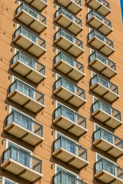 Exterior of apartment building with large glass doors going out to balconies. View from the street of tall commercial houses in downtown San Antonio, Texas.