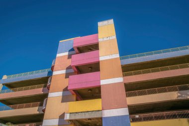Tucson, Arizona 'da çok katlı bir garaj otoparkının alçak açılı görüntüsü. Renkli duvarları ve parmaklıkları olan bir dış bina..