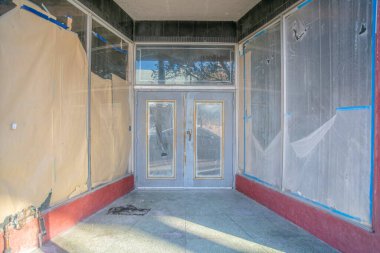 Tucson, Arizona 'da çift kapılı bir iş binasından atılmış. Duvarın solunda cam kapaklı, sağında plastik kaplı bir binanın girişi..