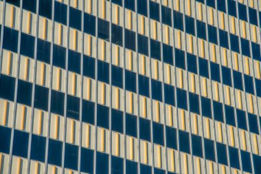 Tucson, Arizona şehir merkezindeki pencere duvarları arasında sarı çizgileri olan modern bir bina. Çok katlı bir binanın dış detayları.