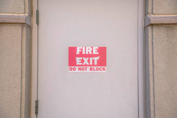 亚利桑那州图森市中心的一扇米黄色的门上 火灾出口不要堵塞 在混凝土墙中间装有侧铰链的门上关上消防出口标志 — 图库照片