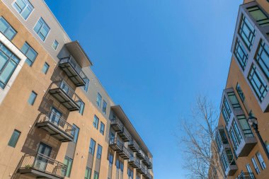 San Antonio, Teksas. Balkonları solda, körfez pencereleri sağda olan apartmanlar. Açık kahverengi ve gri dış görünüşlü apartman kompleksi açık gökyüzü arka planına karşı.