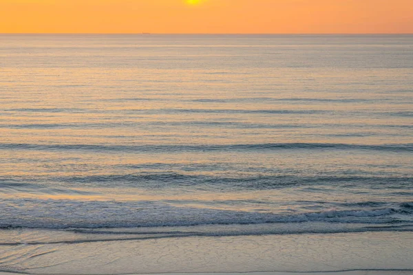 La Jolla, California- Sunset view over the water of the Pacific Ocean. Peaceful view of the calm waves against the sunset sky at the background.