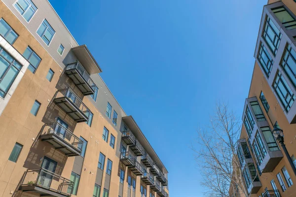 San Antonio, Teksas. Balkonları solda, körfez pencereleri sağda olan apartmanlar. Açık kahverengi ve gri dış görünüşlü apartman kompleksi açık gökyüzü arka planına karşı.