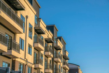 Phoenix, Arizona- modern modern apartman dış tasarımı. Mavi gökyüzü arka planında siyah balkon korkulukları ve metal duvarları olan bir bina manzarası.