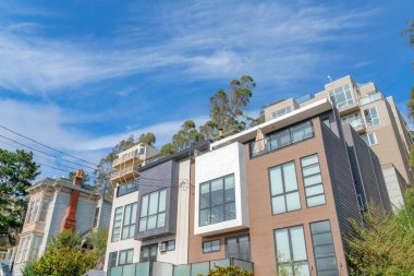 San Francisco, California 'daki modern kasaba evlerinin düşük açılı görüntüsü. Kasaba evlerinin dışı alçak açılı, resim pencereli, balkonlu ve ahşap kaplamalı..