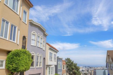 California 'daki San Francisco banliyöleri manzaralı eğimli kompleks evler. Kasaba evleri dış görünüşü gökyüzüne karşı farklı renklerde..