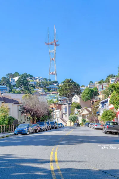 在加州旧金山的Sutro Tower附近 有一条黄线和路边停车场的道路 在靠近山坡的房子前面 有很多车停放在路边 上面有很多房子 — 图库照片