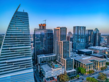 Austin, Teksas 'ta bir şehir manzarasında gökdelen binaları. Arka planda ufukta cam duvarları olan iskan ve finans binaları var..