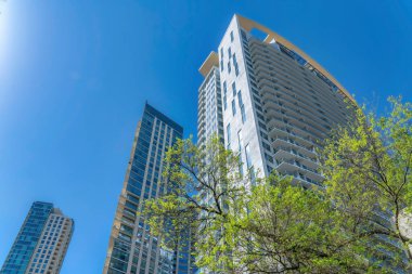 Güneşli bir günde mavi gökyüzüne karşı yükselen daireleri olan Austin Texas silueti. Balkonları ve cam cepheli modern mimarinin yer aldığı konut binalarının dış görünüşü.