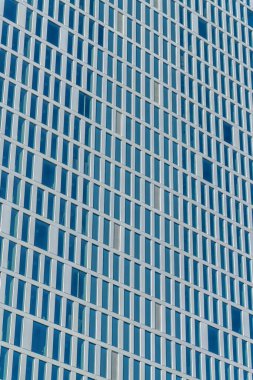 Austin Texas şehir merkezindeki modern gökdelende gökyüzünü yansıtan pencereler var. Güneşli bir günde ön cephesinde cam olan ticari bir ofis binasının dışı..