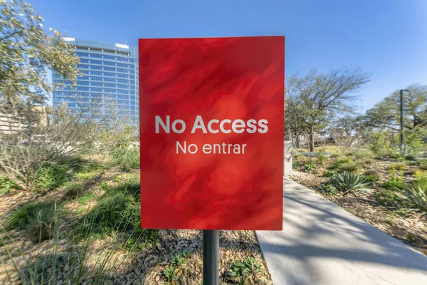 No Access signage by a paved walking trail at Waterloo Park Austin Texas. Close up view of a bright red sign that prohibits visitors to enter an area not open for public at a park.