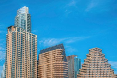 Austin Texas 'taki binalarda gökyüzüne karşı çeşitli şekiller sergileniyor. Şehirdeki daireler veya ticari birimler bu güneşli günde gökyüzü manzaralı bir yer oluşturuyorlar..