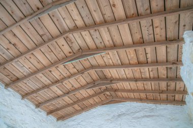 San Antonio Teksas 'ta terk edilmiş bir binanın tavanına bakıyorum. Eski, tarihi ve yıpranmış yapının tavanı kahverengi ahşap levhalardan yapılmıştır..