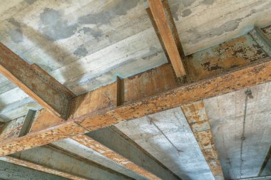 San Antonio, Teksas 'taki River Walk' ta beton köprüyü destekleyen paslı metal kirişler. Metal kirişlerle köprünün altından alçak açılı görüş.