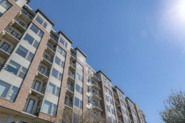 Austin, Teksas 'ın orta katlı apartmanı alçak açılı. Pencereli bir apartmanın ön cephesi ve korkuluklarda bisikletleri olan balkonlar..