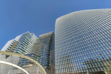 Austin, Teksas. Yüksek binaların modern dış görünüşü alçak açılı. Açık mavi arkaplan üzerinde yansıtıcı cam dış cephe binalar.