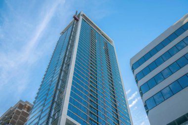 Austin, Texas. Crane asansörü modern bir binanın önüne bağlı. Yansıtıcı camlı binaların düşük açılı görüntüsü.